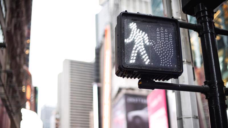 A pedestrian crosswalk sign is shown telling walkers it is safe to walk.