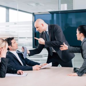 A businessman is shown grabbing a co-worker by the necktie as two women try to intervene.