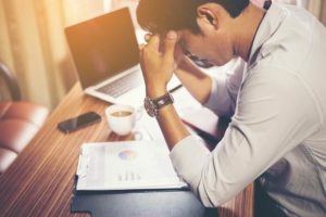 A man is seen reviewing bills after suffering a pedestrian injury.