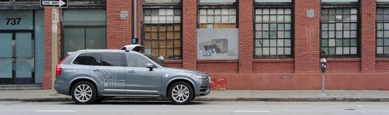 An uber self-driving car is shown on a city street.