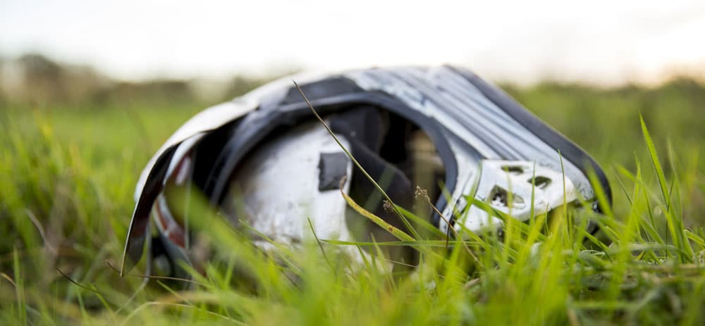 A motorcycle helmet lying in the grass.