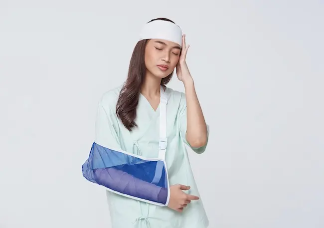 An injured woman with a head bandage and arm sling, representing personal injury claims requiring legal representation for damages recovery.